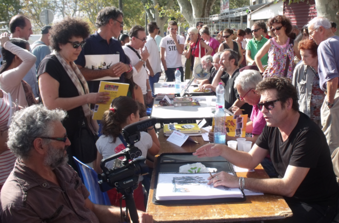 Au 1er plan, de gauche à droite : le réalisateur Claude Hirsch ; Tignous de Charlie Hebdo - 2e édition du Festival International du Dessin de Presse, de la Caricature et de la Satire (2013). © Philippe Léger Au 1er plan, de gauche à droite : le réalisateur Claude Hirsch ; Tignous de Charlie Hebdo - 2e édition du Festival International du Dessin de Presse, de la Caricature et de la Satire (2013). © Philippe Léger